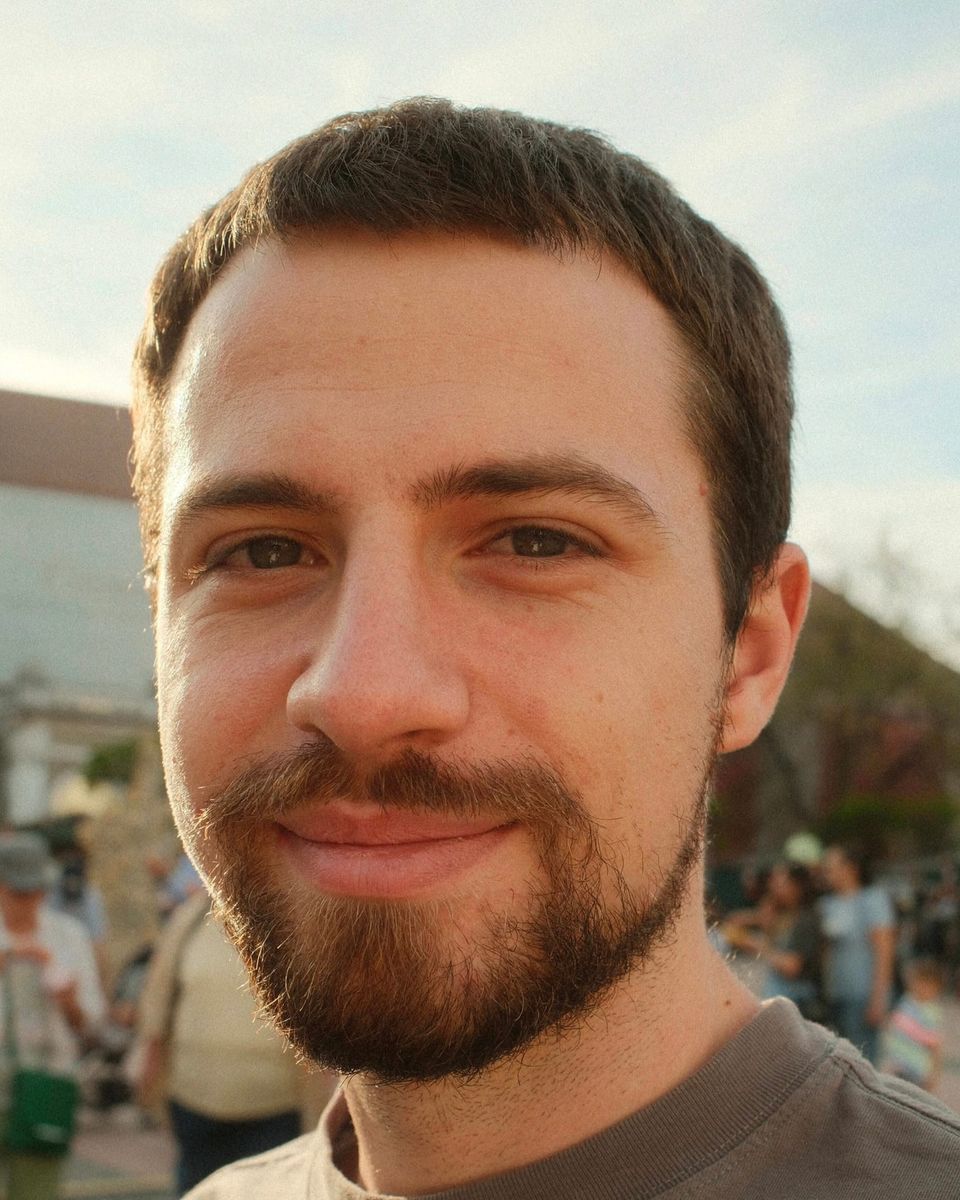 Mihai Nicolae, smiling, in a sunlit town square
